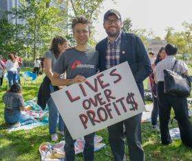 MSF staff hold a sign reading "Lives over profits" as part of the Time for $5 campaign.