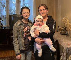 A family displaced from Nagorno-Karabakh stands in a home in Armenia where they are sheltering.