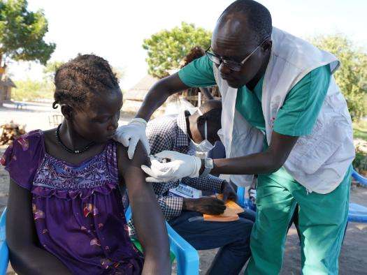 MSF nursing team supervisor Bang Bol administers the first dose of the Hepatitis E vaccine to a woman in Wangmok village, Jonglei state. 