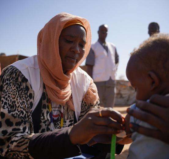 An MSF staff member assessing a child for malnutrition.