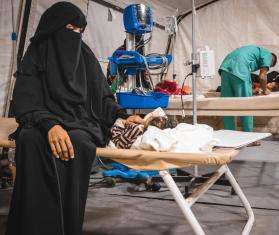 A mother in Yemen with her son on a bed in MSF's field hospital in Yemen.