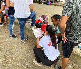 An MSF worker talks with migrants who have exited the Darien Gap in Costa Rica 