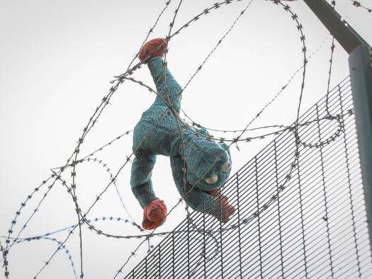 A stuffed animal caught in a barbed wire fence in Calais. 