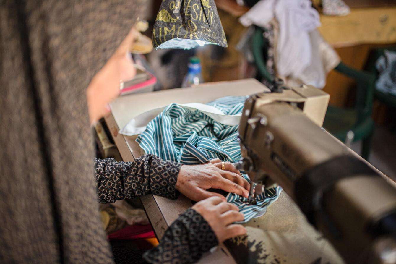 Nour, a Palestinian woman who has lost her husband, uses a sewing machine.