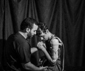 A patient with a braced shoulder receives therapy in a MSF hospital in Amman. 