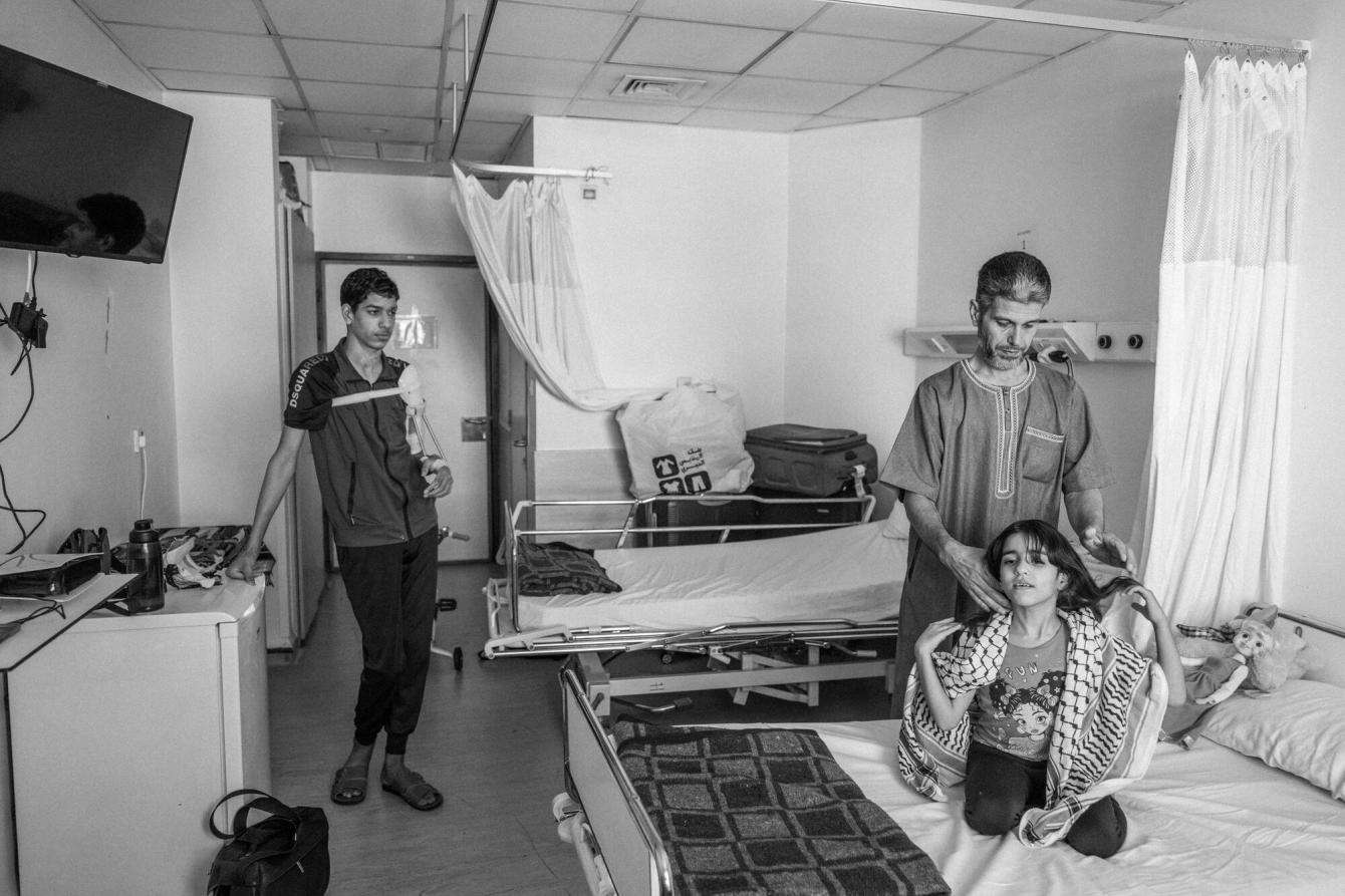 A father and his two children in a hospital room in Amman. 
