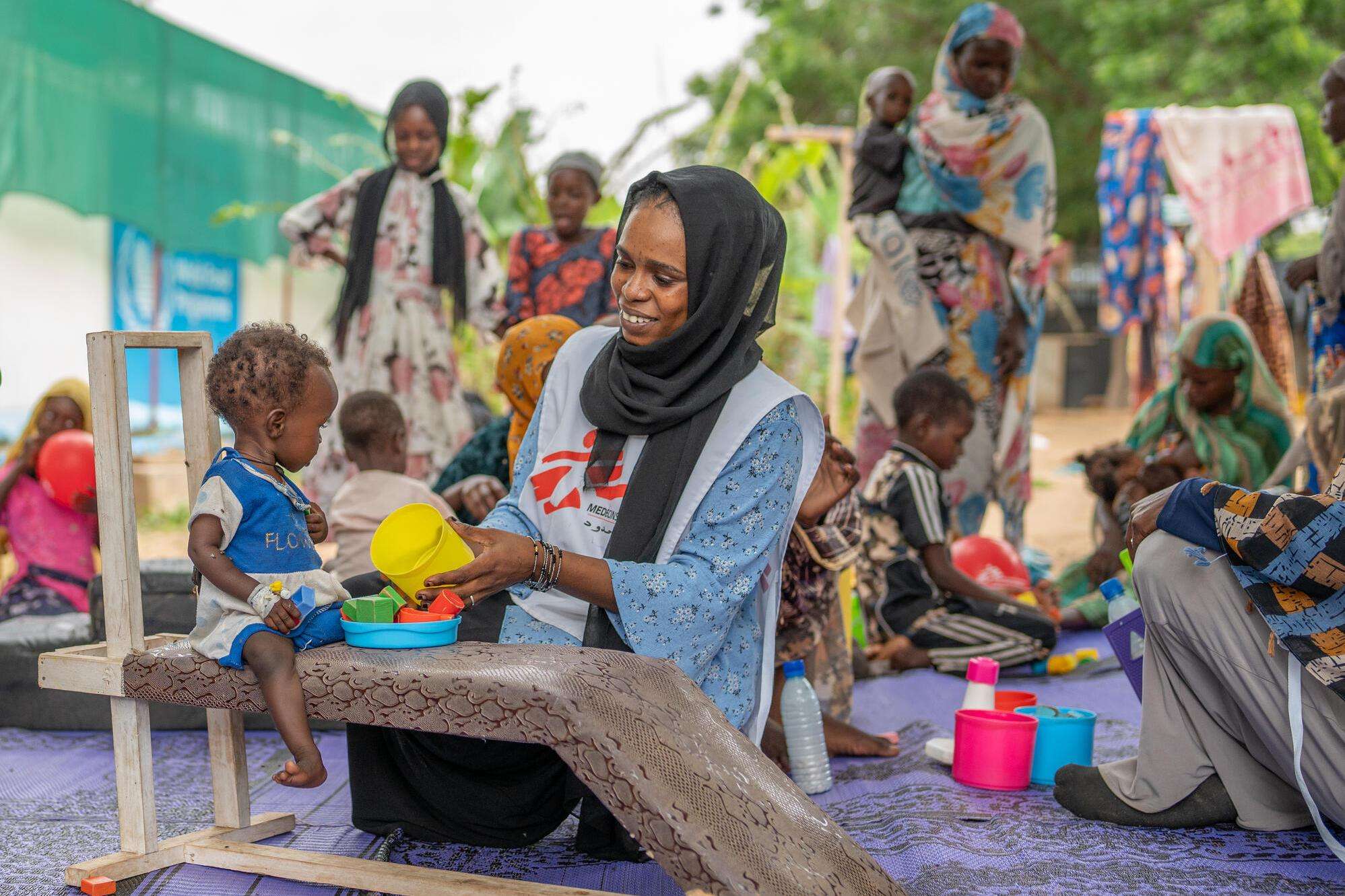 Mental health activity manager Saidi Nabiha and her colleague Zamzam, a Sudanese counselor, provide physiotherapeutic care to patients in the malnutrition ward to counteract developmental delays arising from malnutrition. 
