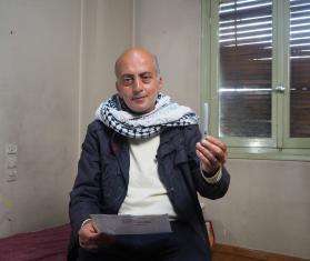 Ghassan, a diabetes patient, holds an insulin pen in Greece. 