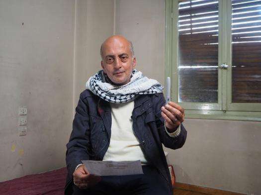 Ghassan, a diabetes patient, holds an insulin pen in Greece. 