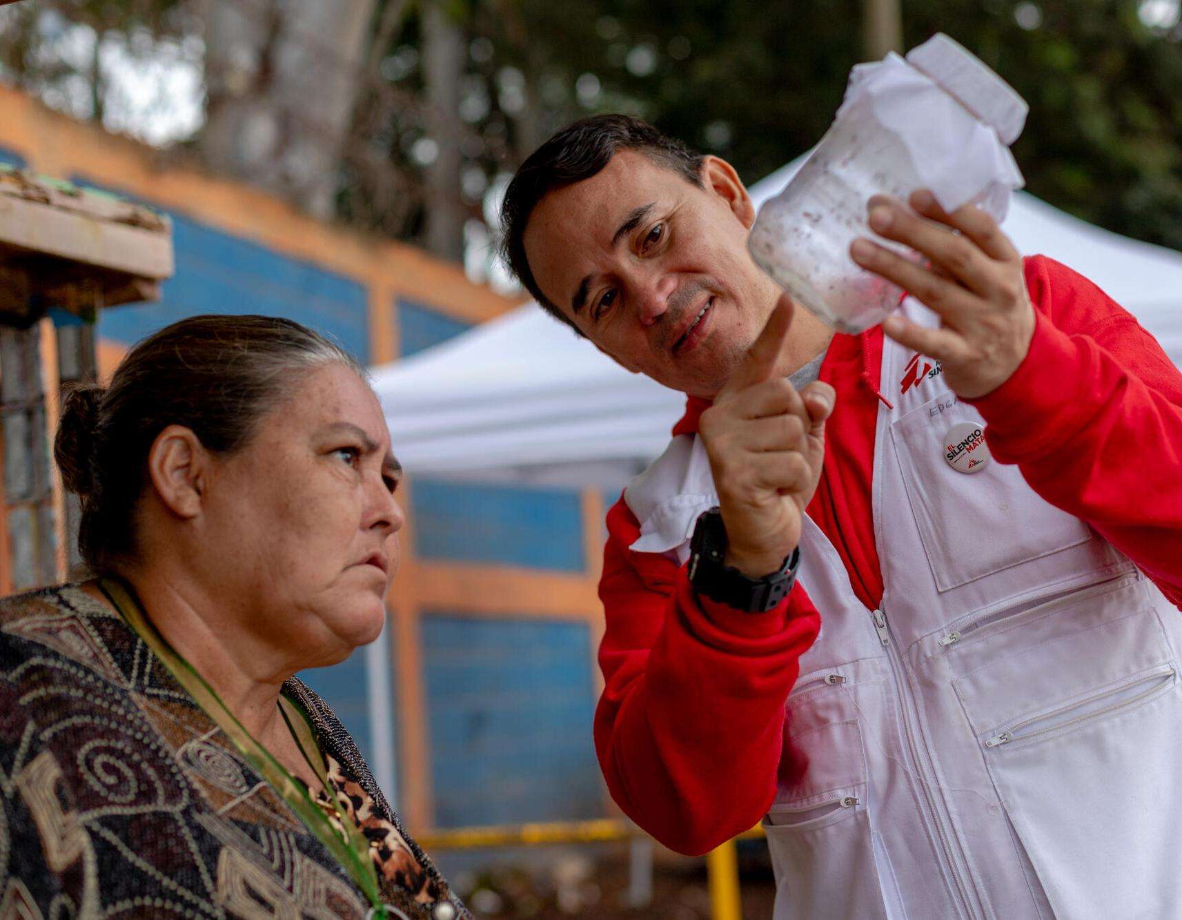 MSF worker explains the science behind wolbachia to resident in Honduras. 