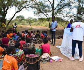 A health promoter holds a mosquito net in Kenya. 