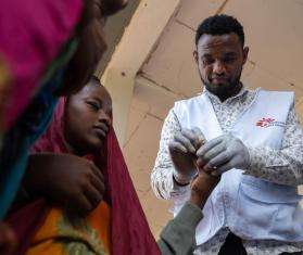 An MSF nurse performs a rapid malaria test on a girl in Ethiopia. 