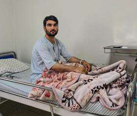 A man sits on a hospital bed in Afghanistan