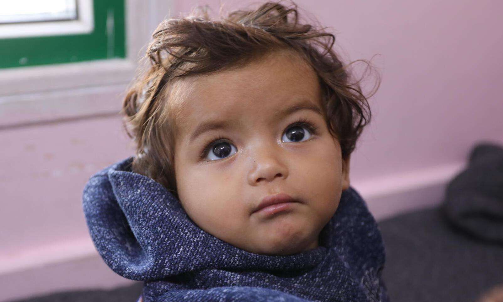 A toddler looks at the camera in Gaza. 