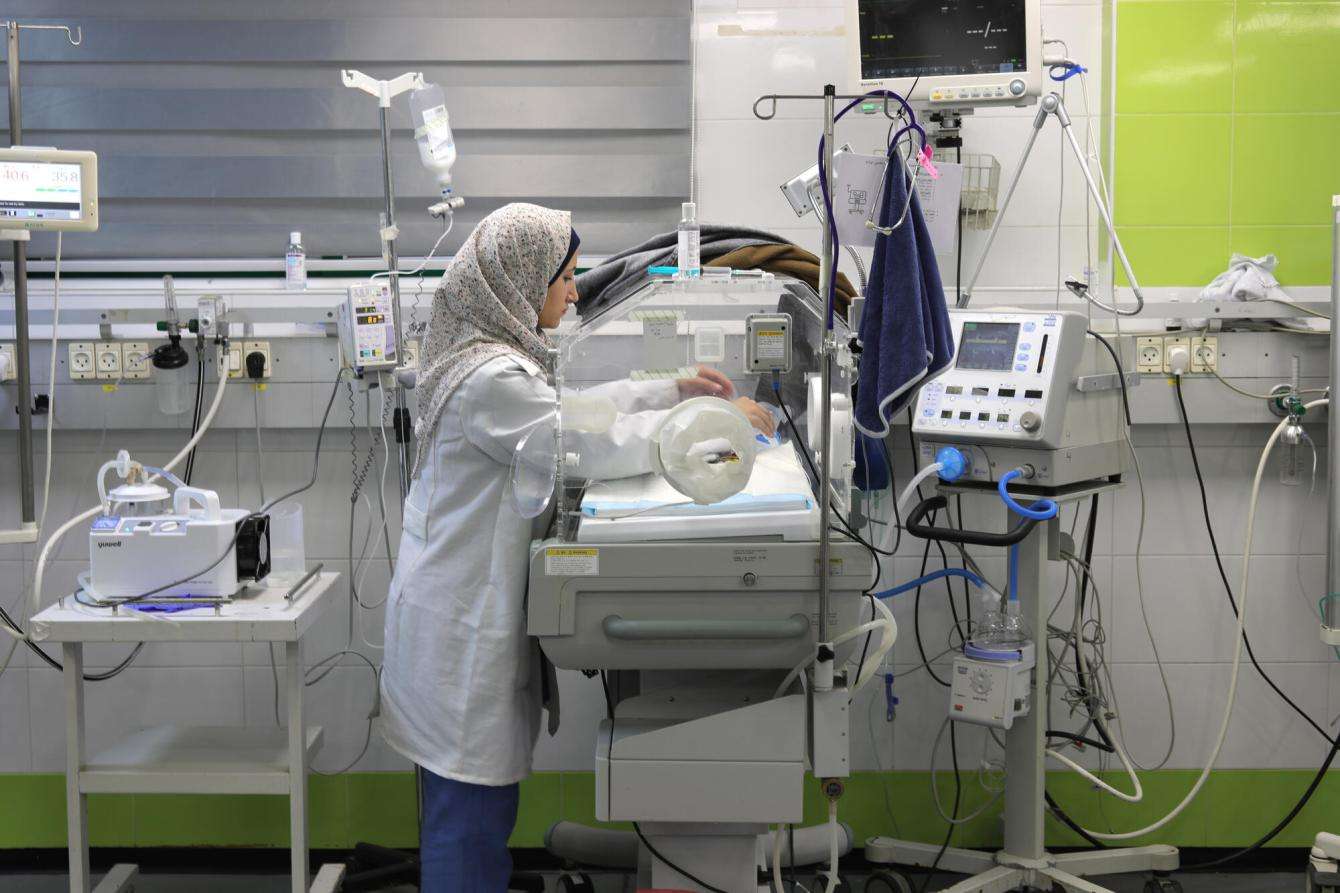 A nurse cares for a newborn in Gaza, Palestine. 