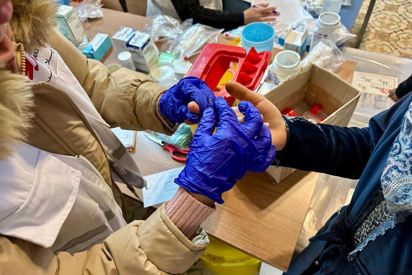 MSF nurse taking a blood sample from a patient at MSF clinic in Jaber, Hebron.