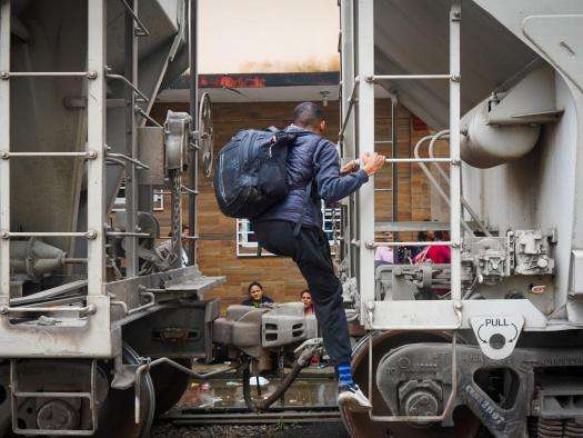 A migrant climbs onto a train in Mexico.