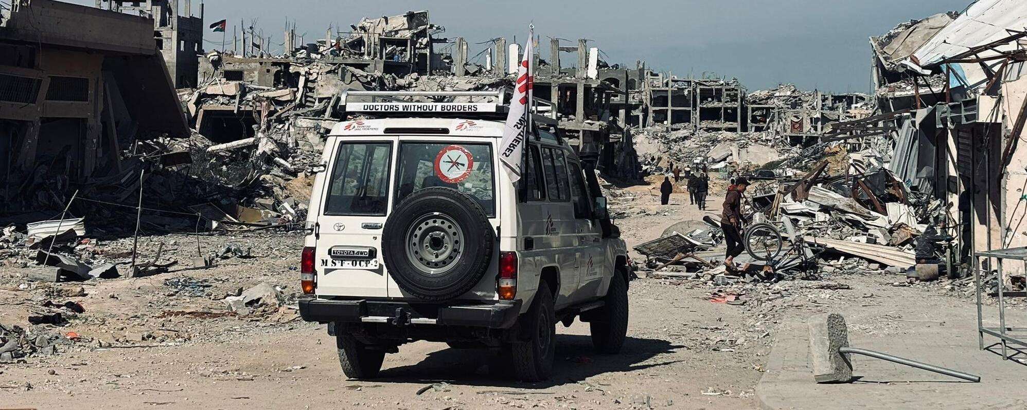 An MSF vehicle drives through the destruction in Gaza.