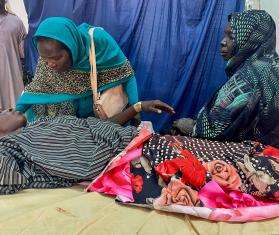 A patient sits with family members at Al Nao Hospital in Sudan. 