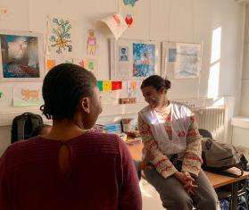 An MSF staff member laughs with a young girl migrant at MSF's day center in Paris, France.