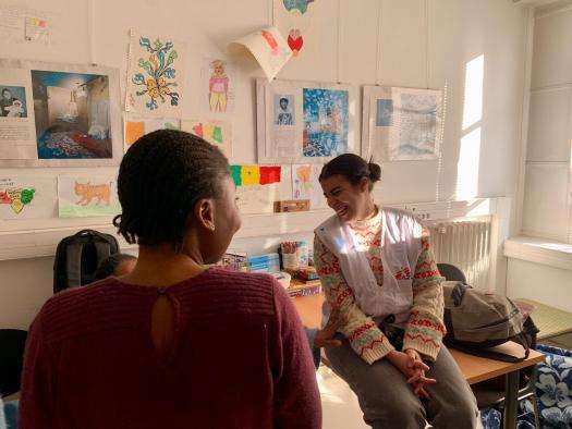 An MSF staff member laughs with a young girl migrant at MSF's day center in Paris, France.