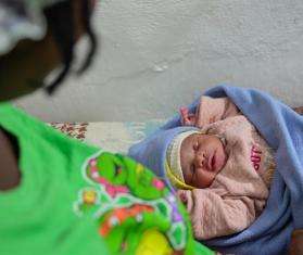 A Haitian woman looks at her baby.