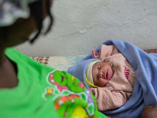 A Haitian woman looks at her baby.