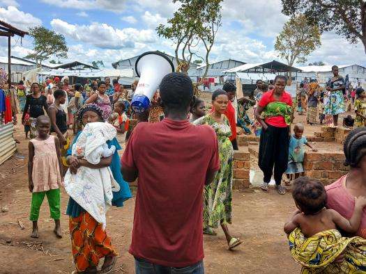 An MSF worker speaks through a megaphone to a crown in Burundi. 