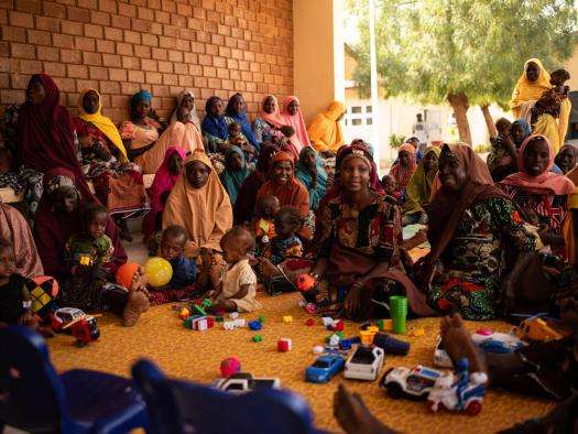 Mothers and children attend a health promotion session in Nigeria. 