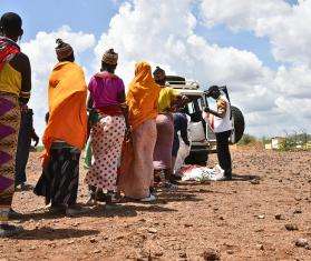 People line up to get a mosquito net in Kenya. 