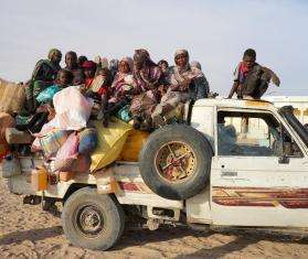 Sudanese refugees arrive on the back of a pickup truck in Chad.