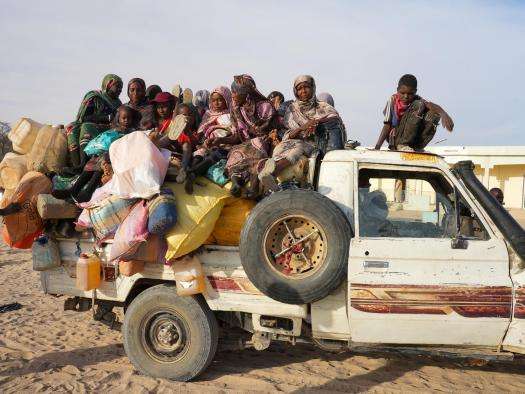 Sudanese refugees arrive on the back of a pickup truck in Chad.