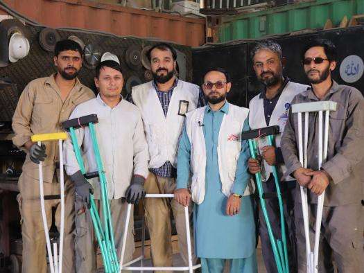 MSF staff hold crutches in Afghanistan. 