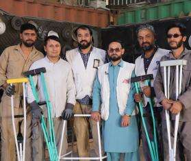 MSF staff hold crutches in Afghanistan. 