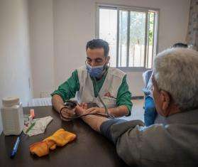 An MSF staff measures a patient's blood pressure in Syria. 