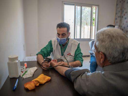 An MSF staff measures a patient's blood pressure in Syria. 