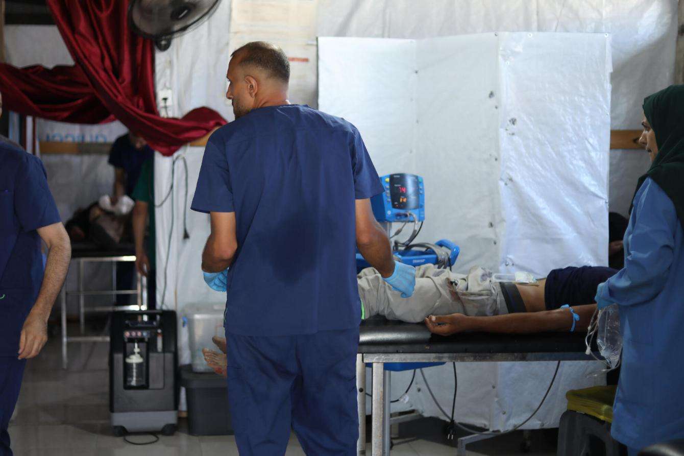 A patient shot while at an Israeli military-controlled aid point is treated in Mawasi, Palestine.
