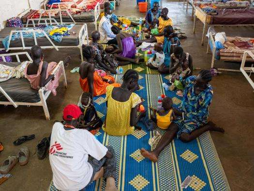 Parents and children sit on the floor at a therapeutic feeding center in Ethiopia. 