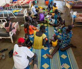 Parents and children sit on the floor at a therapeutic feeding center in Ethiopia. 