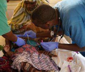 Doctors care for a malnourished child in Somalia. 