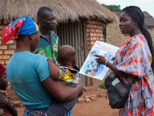 An MSF staff explains a malaria vaccine to a family in Chad. 