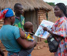 An MSF staff explains a malaria vaccine to a family in Chad. 