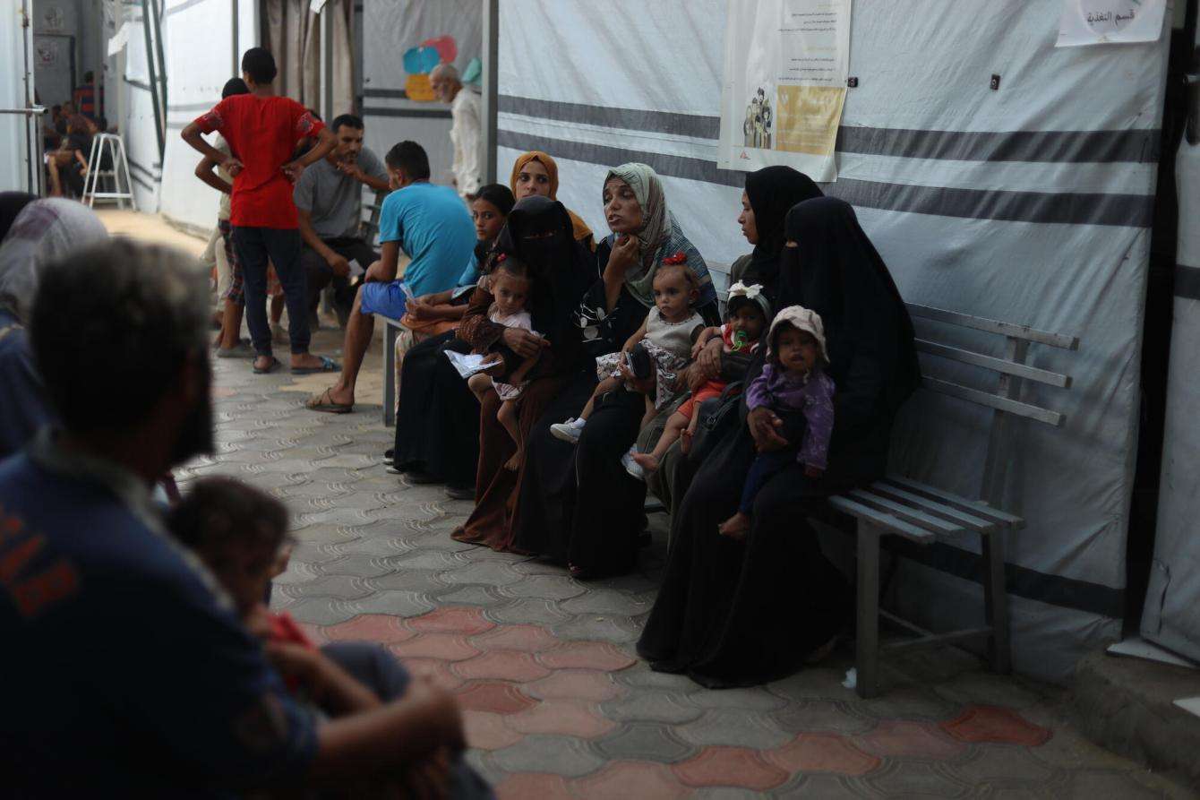 Mothers wait to be seen with their malnourished children at Al-Attar clinic.