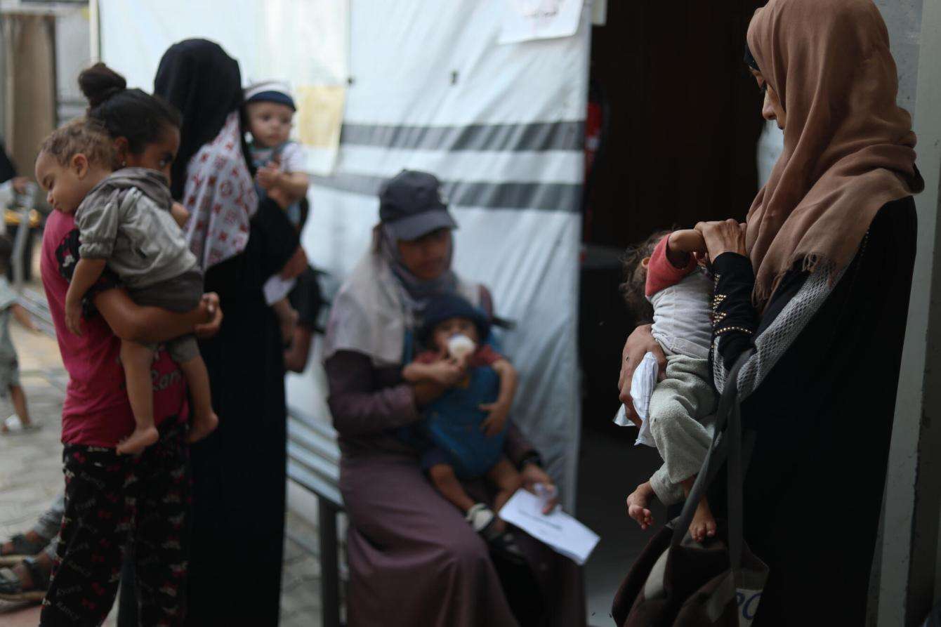 Mothers and their severely malnourished babies wait to be seen by medical staff at Al-Attar clinic.