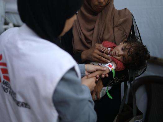 An MSF nurse examines 8-month-old Nour, who is severely malnourished.