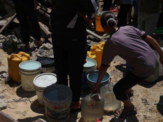 A girl holds a water bucket in Gaza, Palestine. 