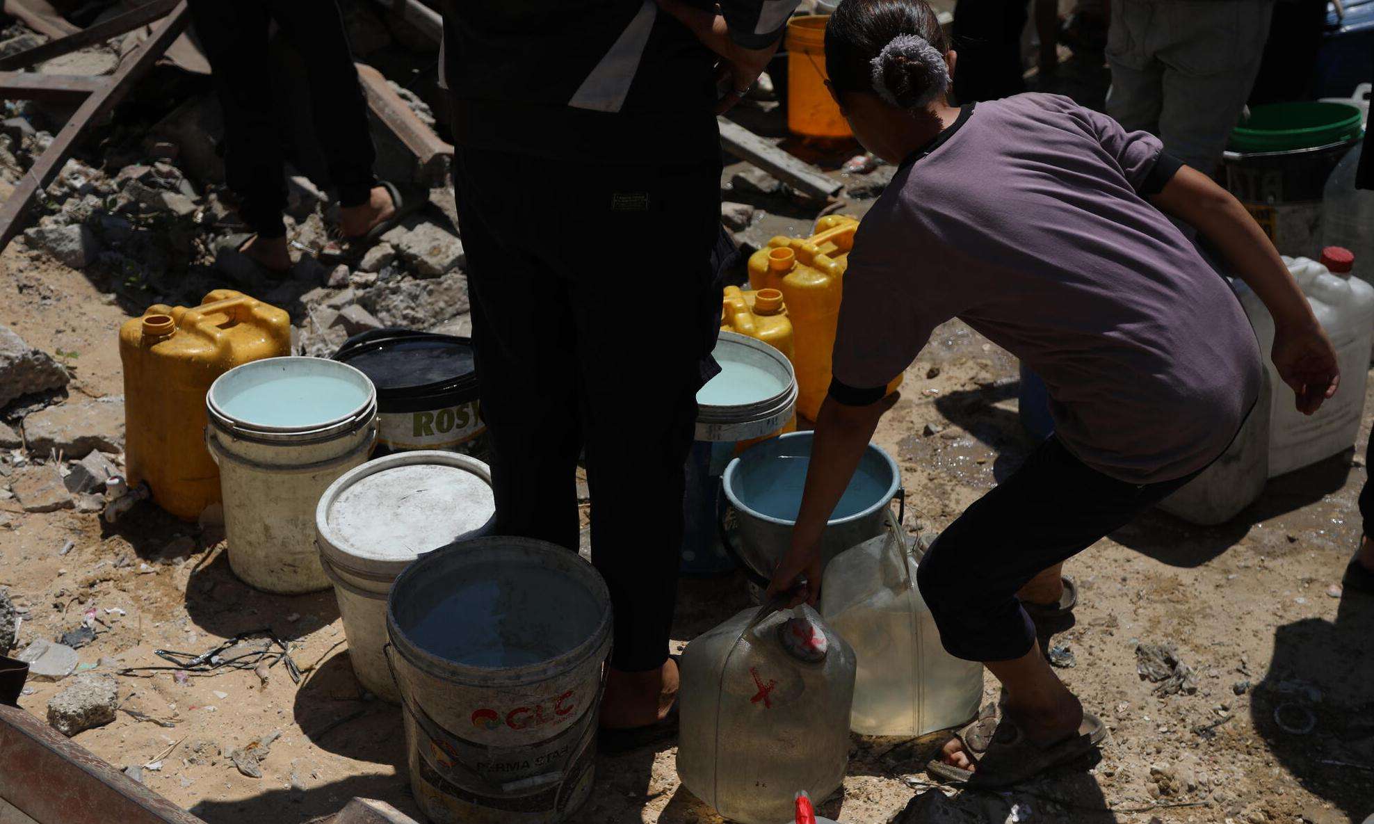 A girl holds a water bucket in Gaza, Palestine. 