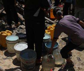 A girl holds a water bucket in Gaza, Palestine. 