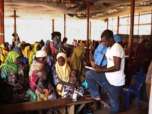 An MSF staff member takes information from new patients at the outpatient therapeutic feeding center in the Jega local government area of Kebbi state.