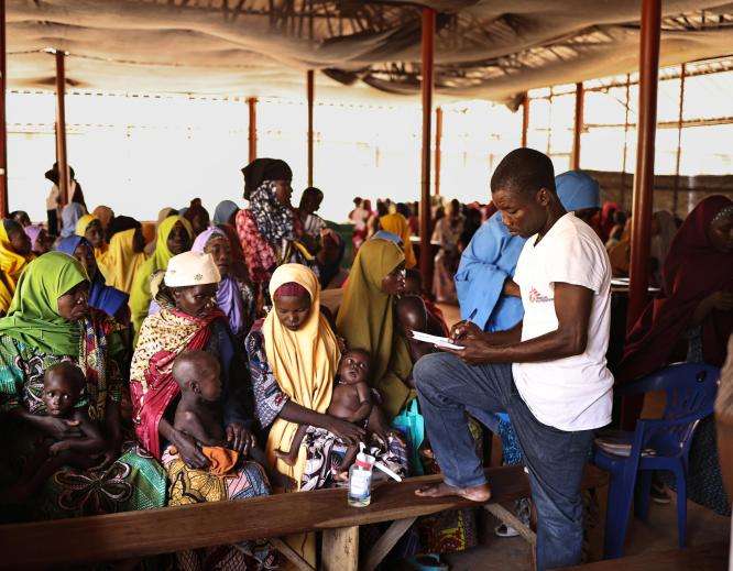 An MSF staff member takes information from new patients at the outpatient therapeutic feeding center in the Jega local government area of Kebbi state.